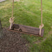 Wooden swing with engraved message in a garden setting