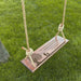 Wooden swing with engraved father memorial design on grass