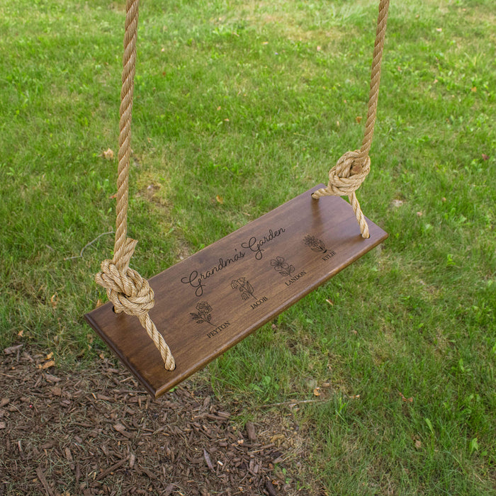 Tree swing hanging in a yard with a personalized design for grandma
