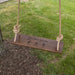 Wooden swing hanging from a tree that has a floral design engraved on it