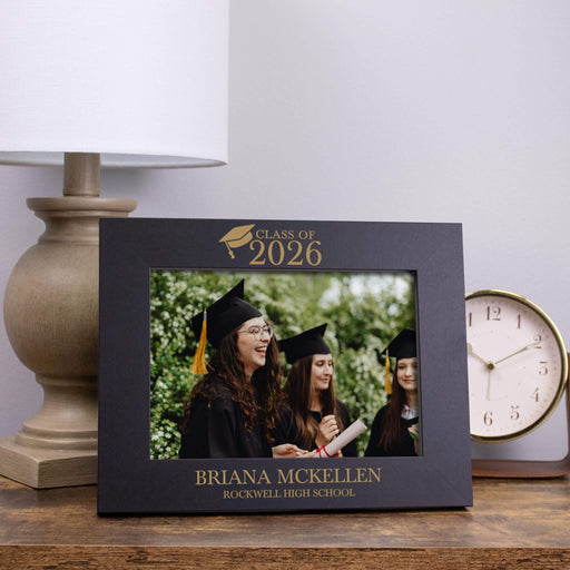 Graduation-themed photo frame with 'Class of 2026' text on a wooden surface.