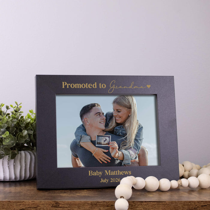 Black horizontal picture frame showing a smiling couple holding a sonogram picture