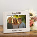 Personalized photo frame with a family picture and text on a wooden surface with flowers.