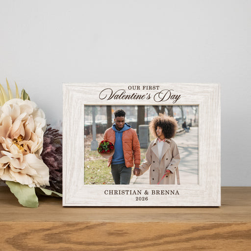rustic white picture frame engraved with "Our First Valentine's Day" on top and the couples names and year at the bottom