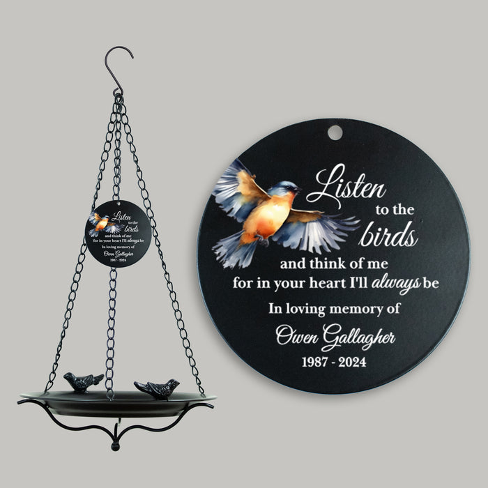 Decorative hanging bird feeder with a circular plaque featuring text and a bird illustration on a gray background.