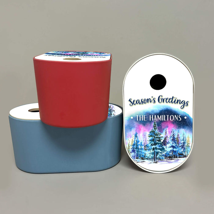 Three bird houses with custom printed designs, one in red, one in white, and one in light blue. Designed with a winter forest illustration and the text 'Season's Greetings THE HAMILTONS'.