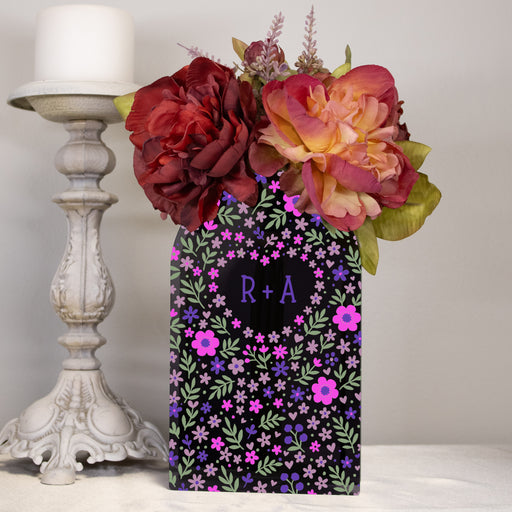 black acrylic flower vase with a pink purple and green floral design and personalized initials of a couple in a heart 