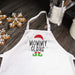 A white kitchen apron with a 'Mommy Claus' holiday graphic, laid flat on a dark wooden tabletop next to gingerbread cookies and kitchen utensils.
