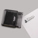 A black self-inking stamp shown on a gray background, with a sample stamped address printed on a white sheet of paper.
