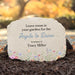 Memorial stone with printed text and floral design in a garden setting