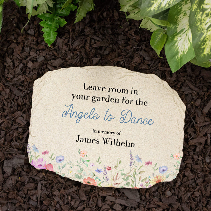 Memorial stone with printed text and floral design on garden mulch