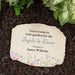 Memorial stone with printed text and floral design on garden mulch