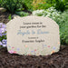 Memorial stone with floral design and text in a garden setting