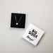 Gold necklace in a box with 'Big Sister' on a light gray background