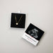 Gold heart necklace in a box with an ultrasound photo and message on a light gray background