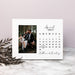 Calendar picture frame with a photo of a couple and personalized names on a marble surface.