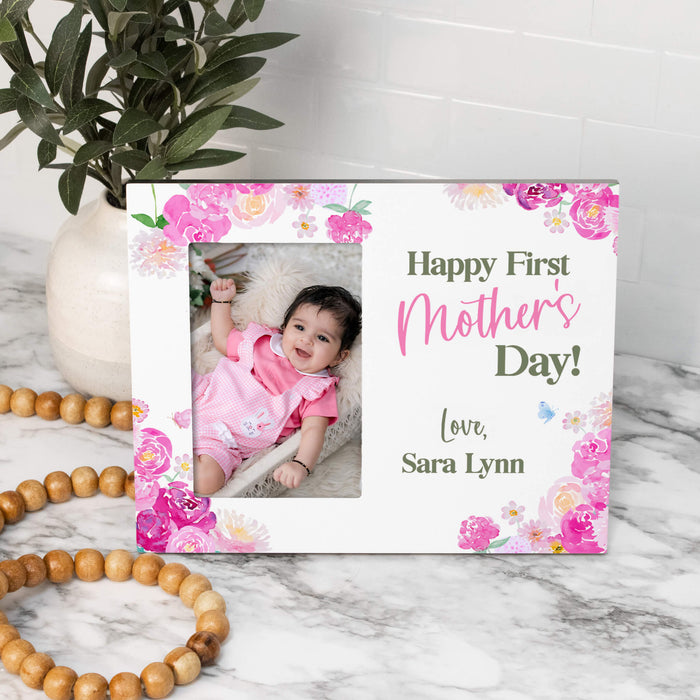 Personalized photo frame with a baby's first Mother's Day message on a marble surface.