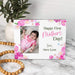 Personalized photo frame with a baby's first Mother's Day message on a marble surface.