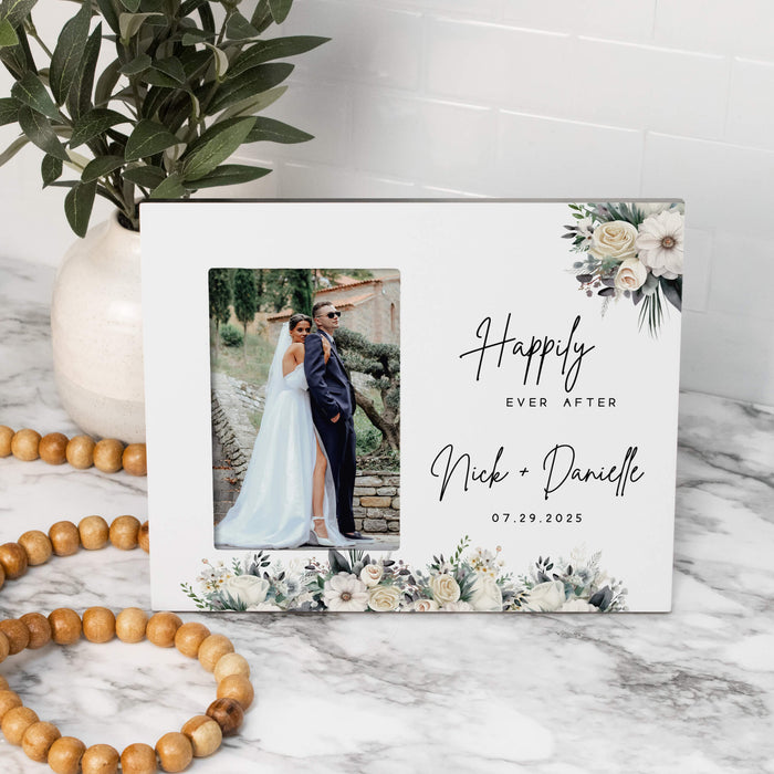 Personalized photo frame with a couple's wedding photo and text on a marble surface.
