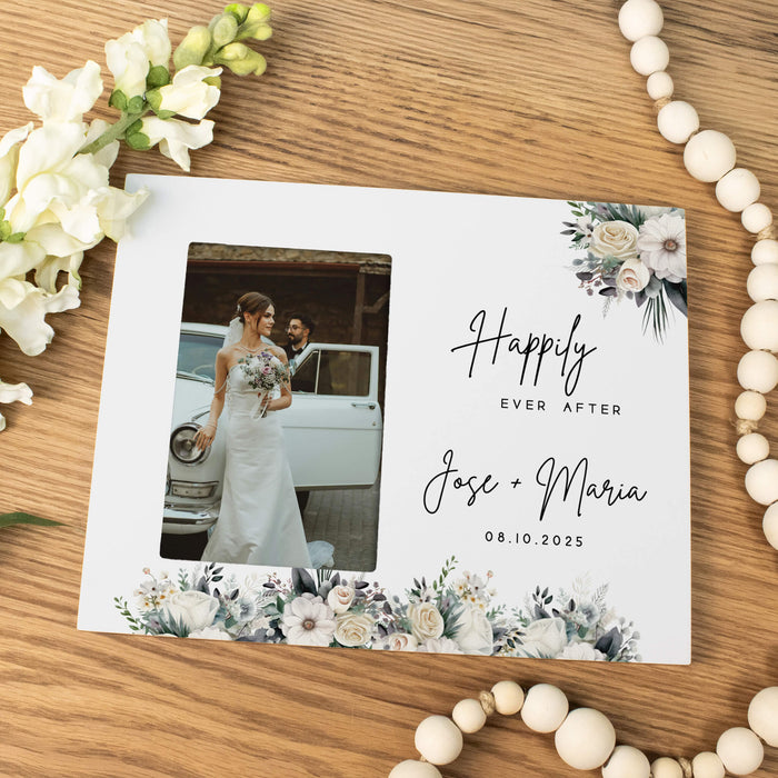 Wedding photo frame with 'Happily Ever After' text and floral design on a wooden surface.