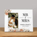 Personalized wedding photo album with 'MR & MRS' text and pink floral design on a wooden surface.
