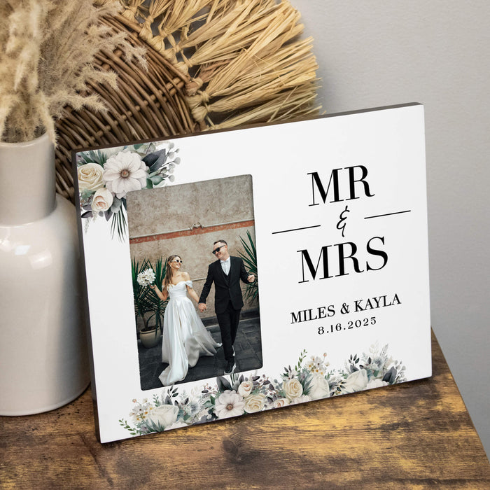 Personalized 'MR & MRS' photo frame with a couple's wedding photo on a wooden surface.