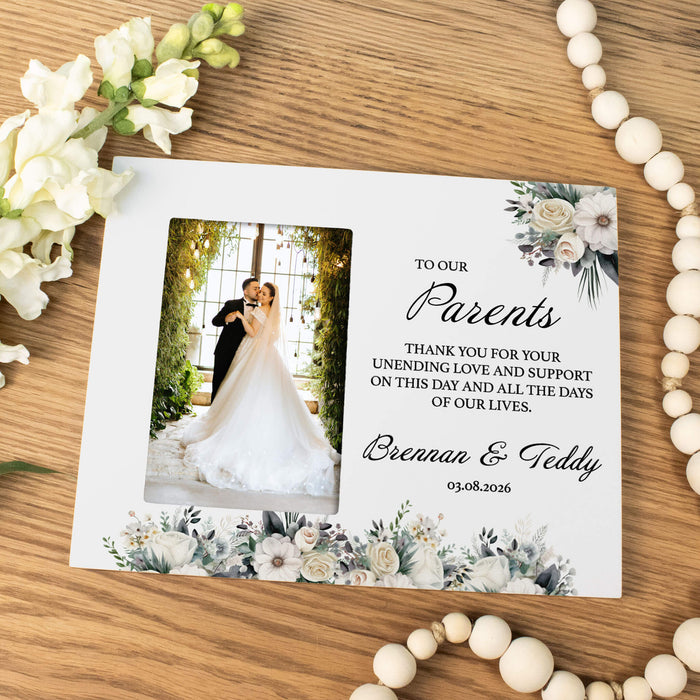 Wedding picture frame for parents with a photo of a couple and floral design on a wooden surface.