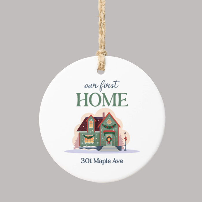 white ceramic circle Christmas ornament printed with 'Our First Home,' a personalized address, and a graphic of a festive home
