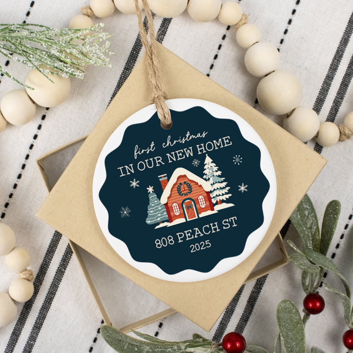 keepsake ornament for new home owners first christmas with address and year laying on the open box surrounded by decorative beads and greenery