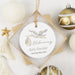 Decorative ornament with baby announcement text, surrounded by Christmas ornaments on a light background