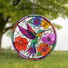 Stained glass acrylic panel with a colorful hummingbird and flowers, hanging outdoors