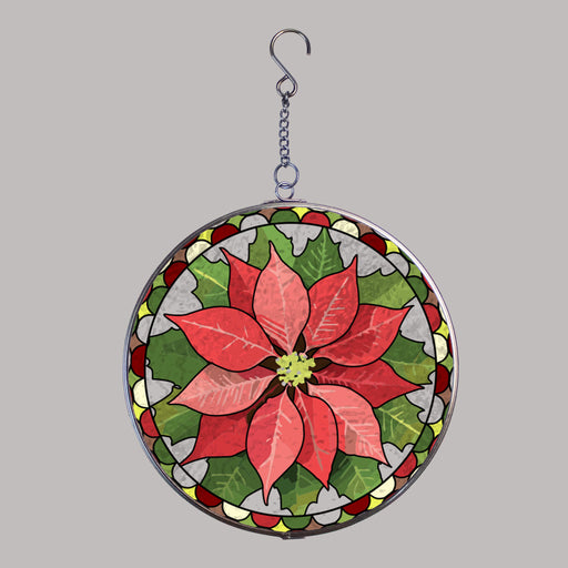 A circular hanging suncatcher stylized with a poinsettia flower in red and pink tones with green leaves, outlined in a silver metal frame and suspended by a short chain from a hook.