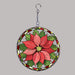 A circular hanging suncatcher stylized with a poinsettia flower in red and pink tones with green leaves, outlined in a silver metal frame and suspended by a short chain from a hook.