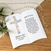 Personalized ceramic book with floral cross design and religious text on a wooden surface with a rosary.