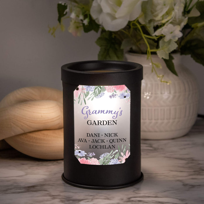 Wax warmer with a floral label that says "Grandma's Garden" on a marble surface, with flowers and a vase in the background.