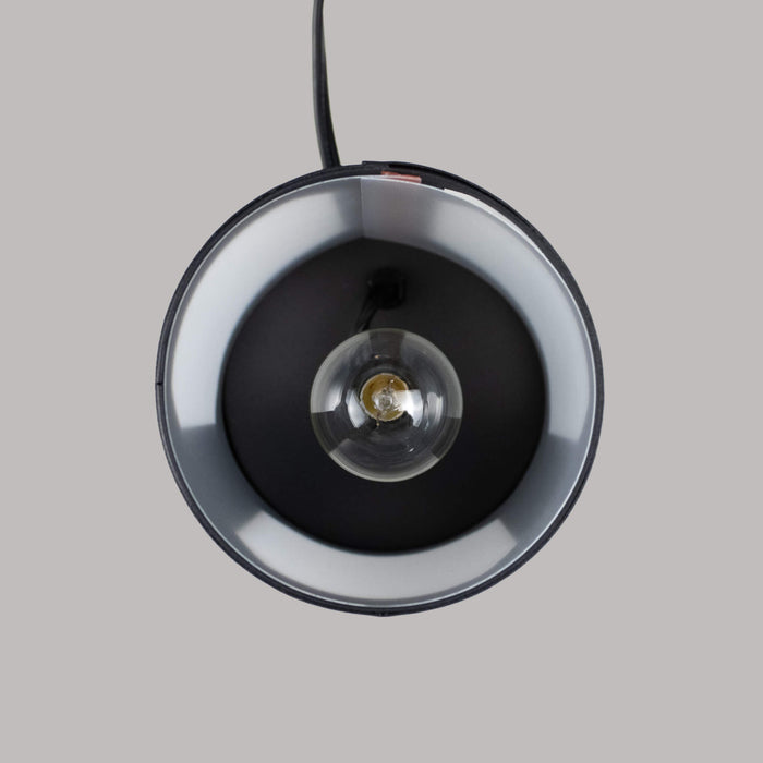 The inside of a black metal wax warmer showing the bulb