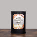 A black cylindrical wax warmer lamp standing on a wooden surface against a light gray background, with a decorative front label that reads 'grateful THANKFUL blessed' around a white pumpkin and autumn leaves.