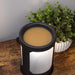 Black light up wax warmer on a wooden surface next to a potted plant