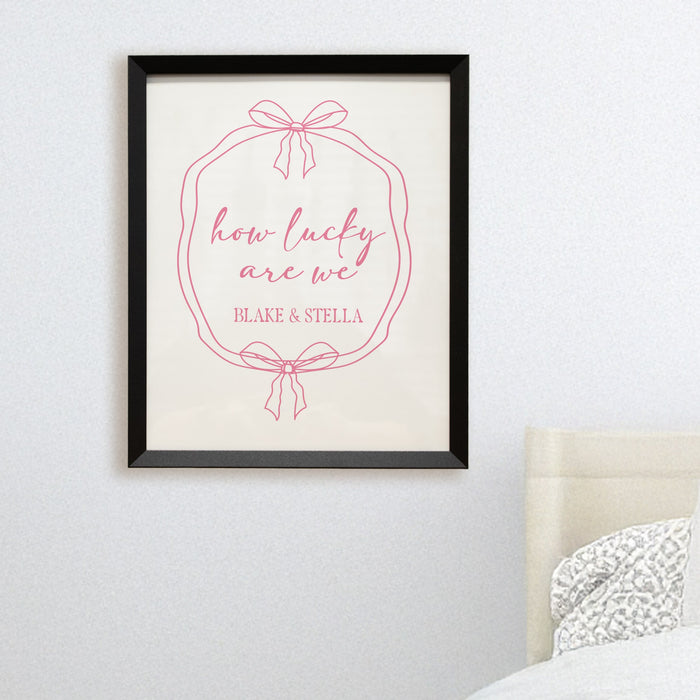 Framed print with 'how lucky are we' and roommates' names on a wall above a bed.