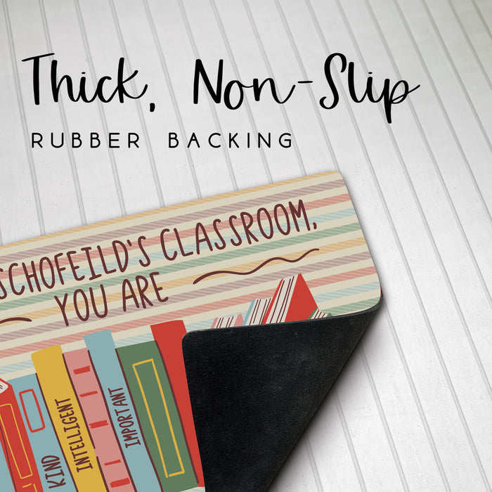 Classroom doormat with book design and text about thick, non-slip rubber backing on a striped background.