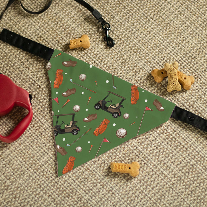 Dog bandana with golf-themed design on a textured surface with dog toys.