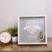 Personalized retirement shadow box with police badge on table next to clock and plant