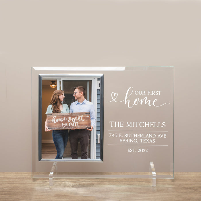 Personalized first home photo frame with a couple holding a 'home sweet home' sign, against a beige wall.