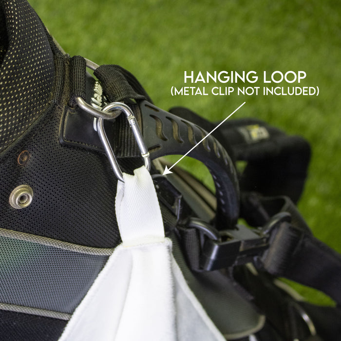 Close-up of a hanging loop of a golf towel on a black bag with grass background