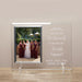 Glass frame with a photo of a bride and bridesmaids, engraved text, on a beige wall.