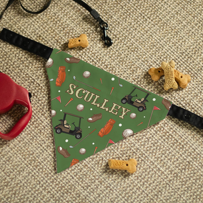 Personalized golf-themed dog bandana on a textured surface with dog toys.