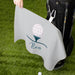 Golf towel with a golf ball and club design on a grassy background