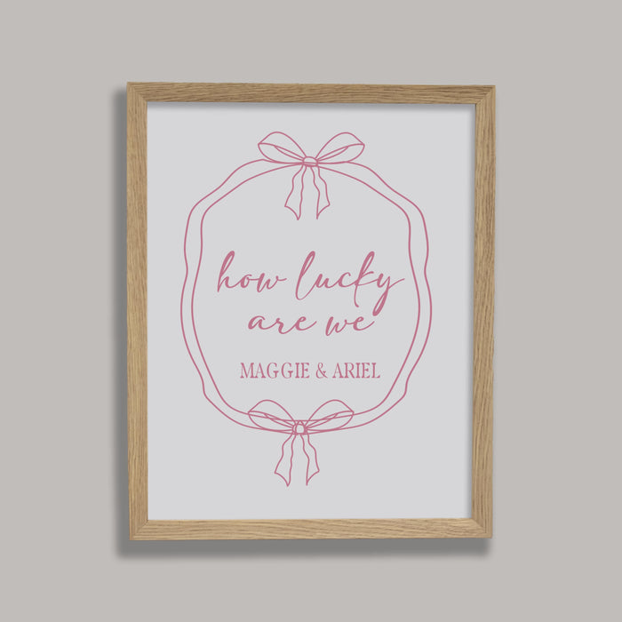 Framed print with 'how lucky are we' text and a bow design on a gray background