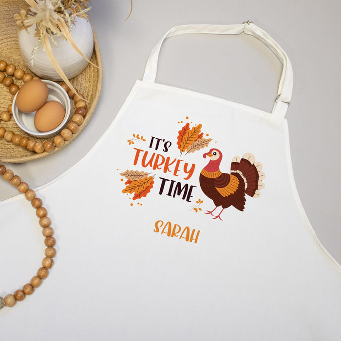 White apron with personalized  'It's Turkey Time' design on a neutral background