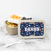 Personalized lunch box with sports pattern and name  on a marble surface.